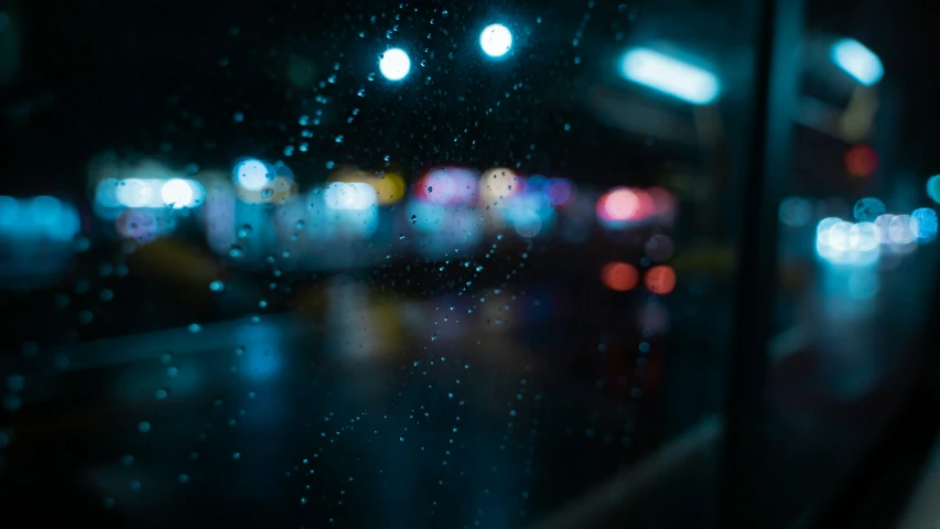 some rain and traffic lights seen through a window