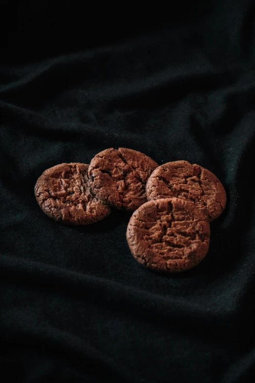 three chocolate cookies on a black background