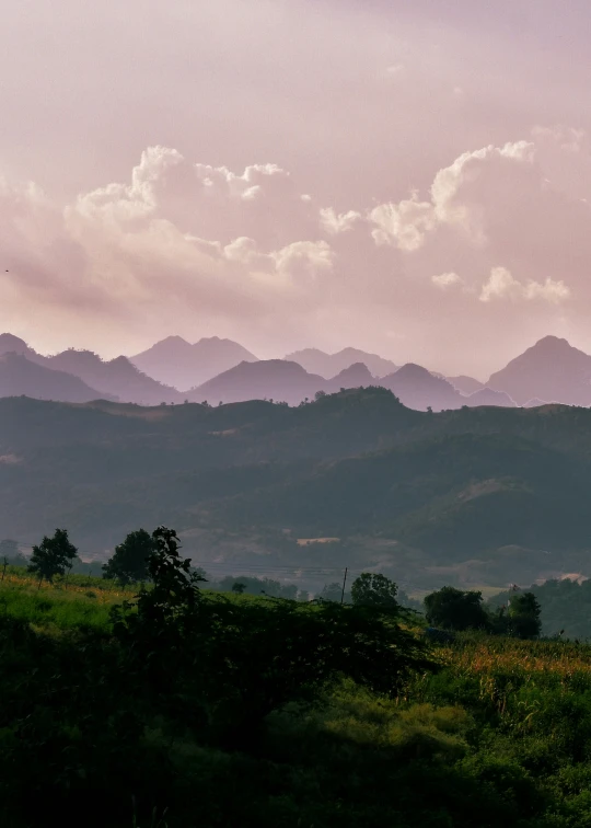 a view of mountains in the distance with clouds over them