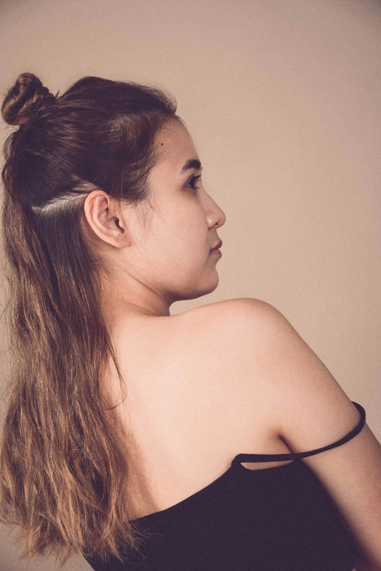 an asian woman looking over her shoulder with long hair