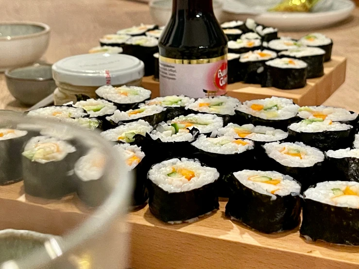 many sushi are displayed along with a bottle of sake