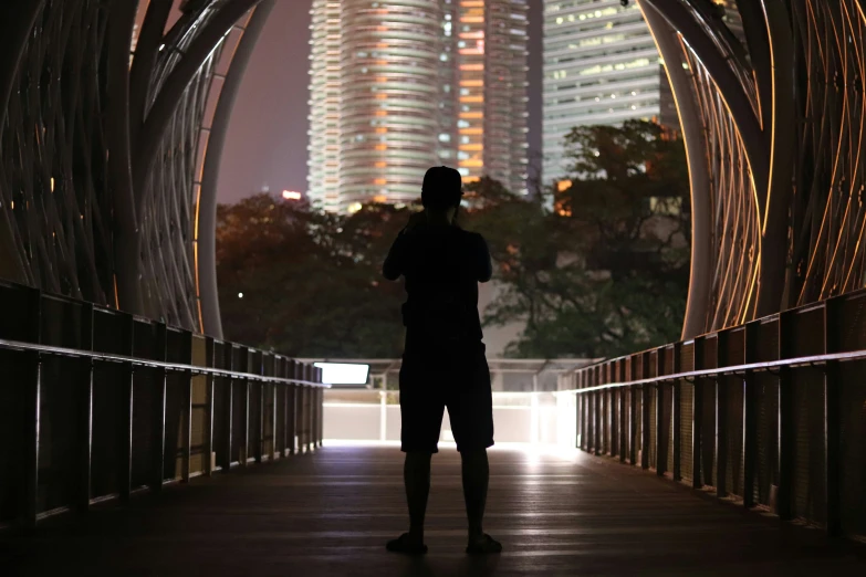 the person is standing outside under a lighted building