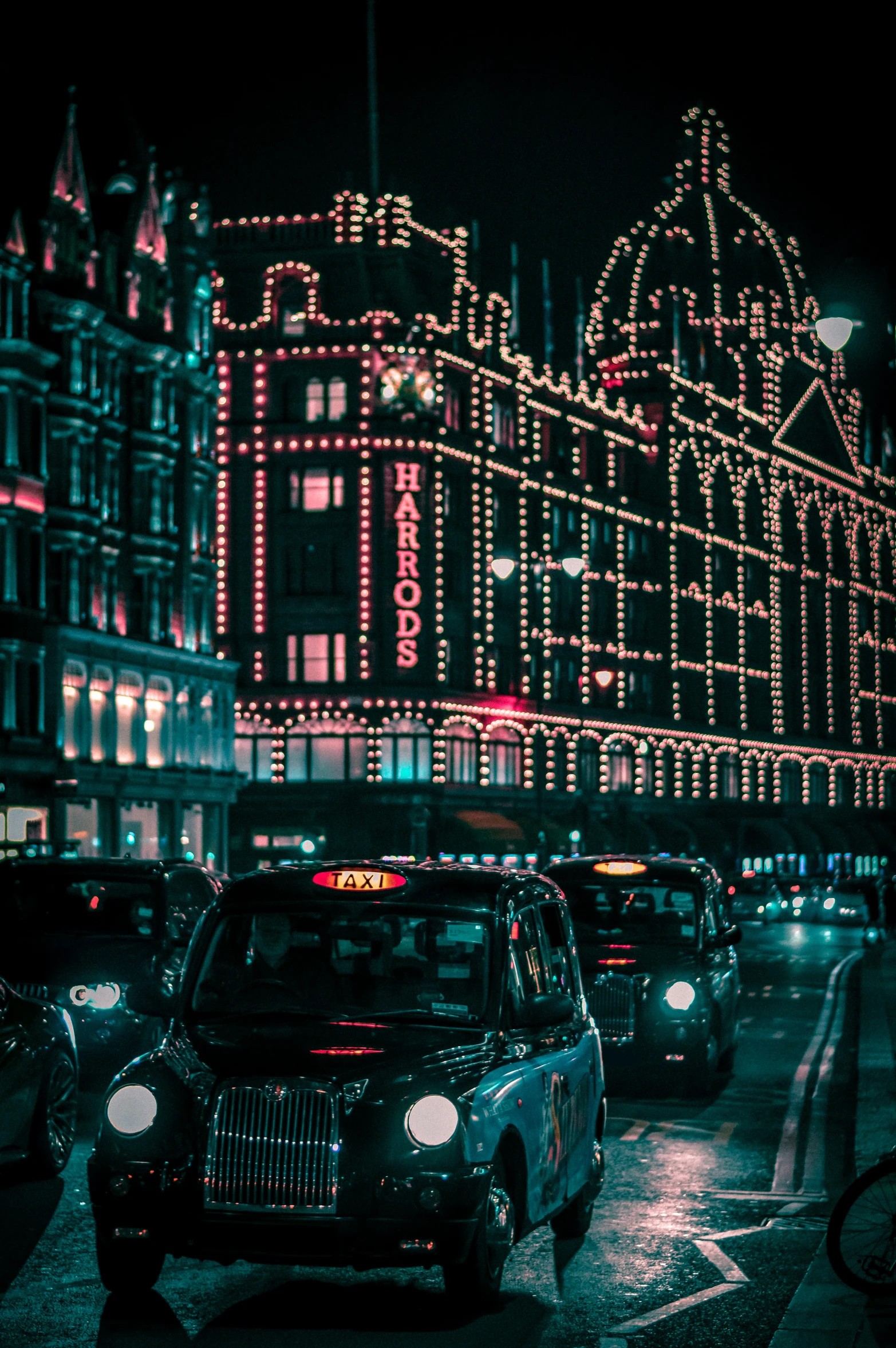 many cars parked along side of a tall building