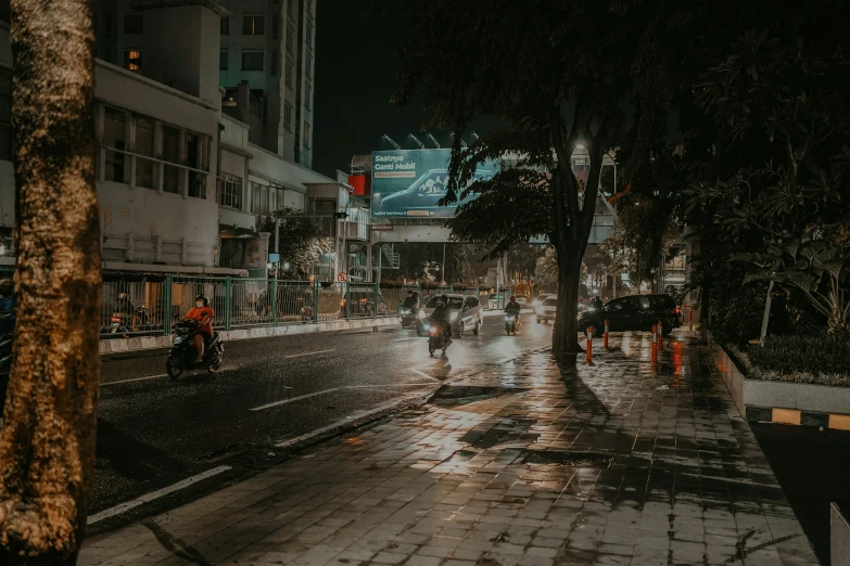 a crowd of people riding bicycles down a rain soaked street