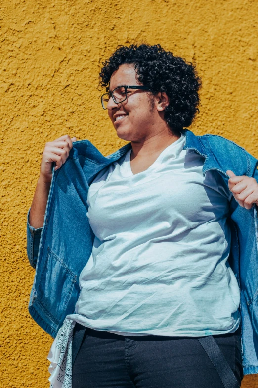 a woman stands with her jacket open and laughing