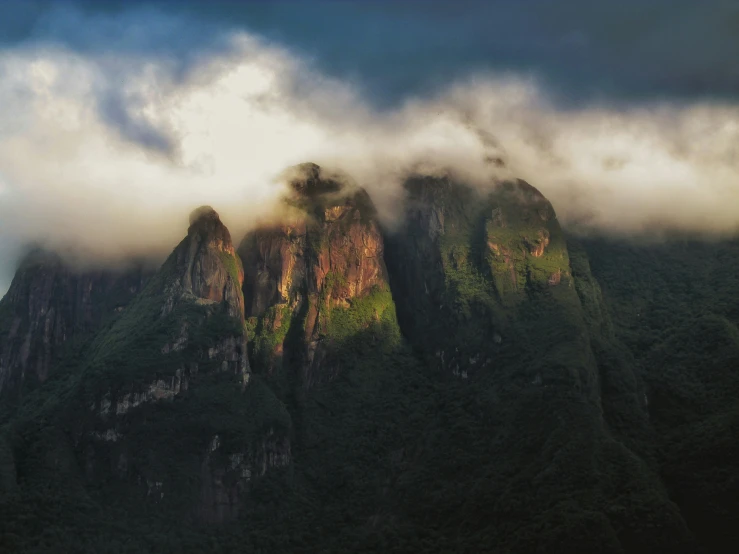 a mountain covered with lush green vegetation under a cloud