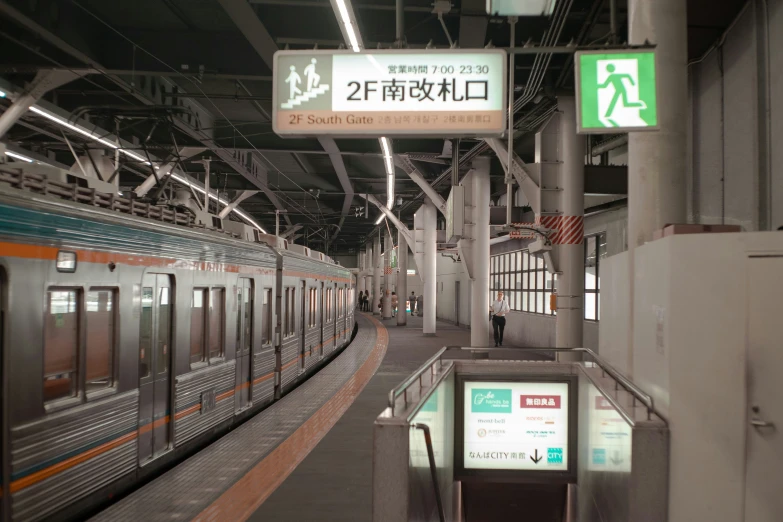 a subway station has a large train pulling in to the station