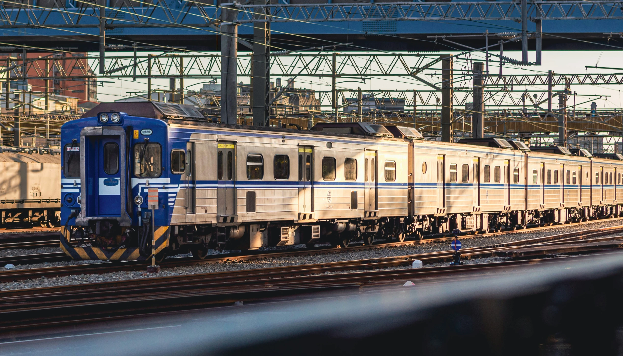 a blue train is pulling a large long line of passenger cars