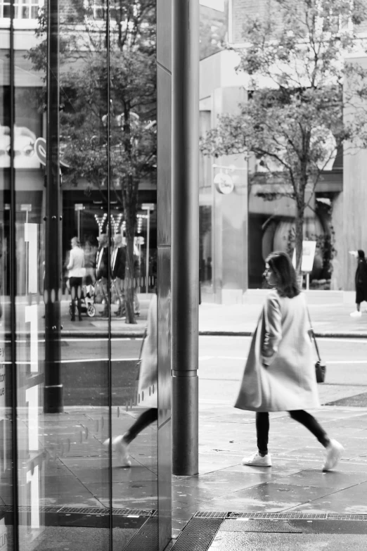 a black and white po of a woman walking down a street