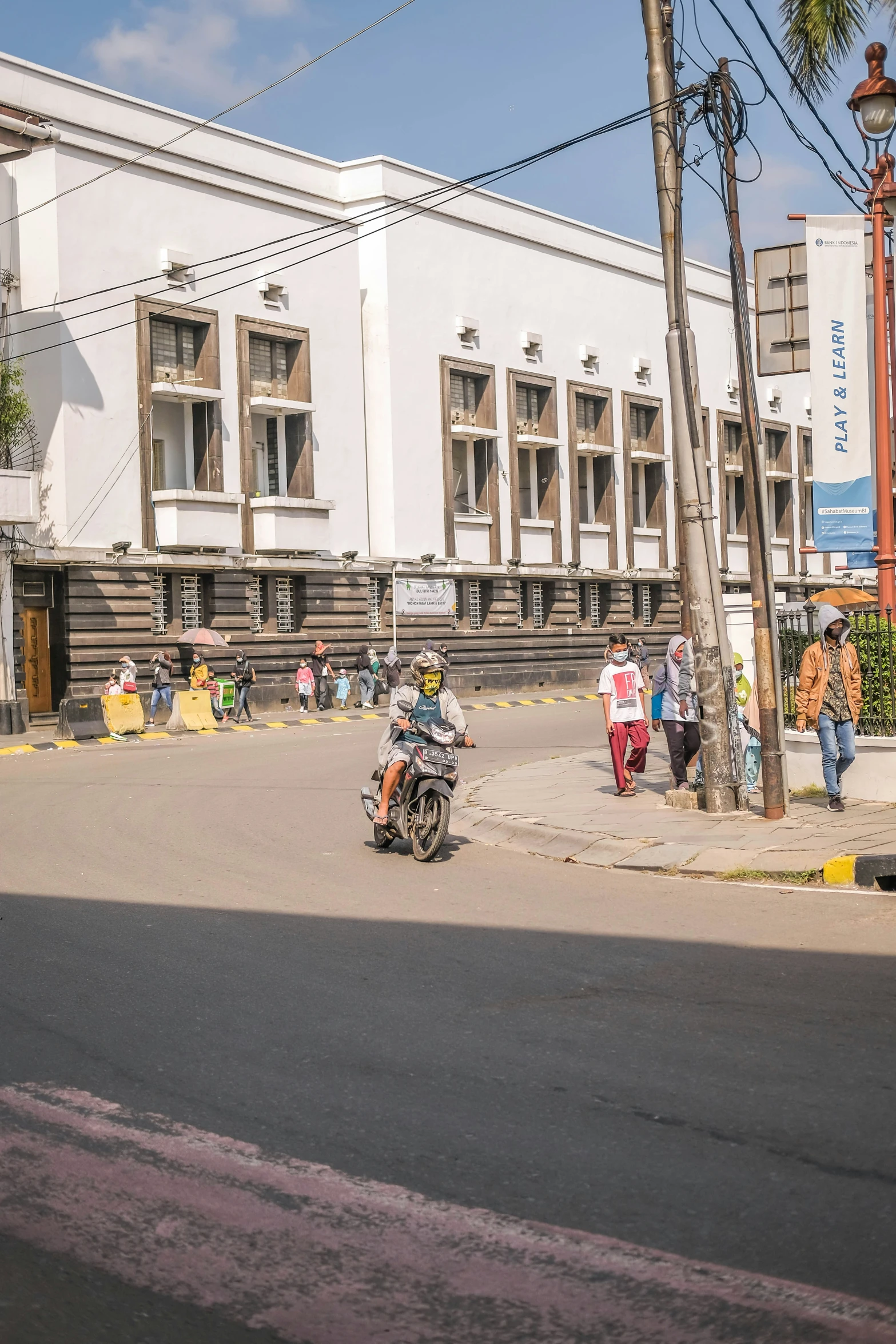 people walking down a sidewalk near a large building