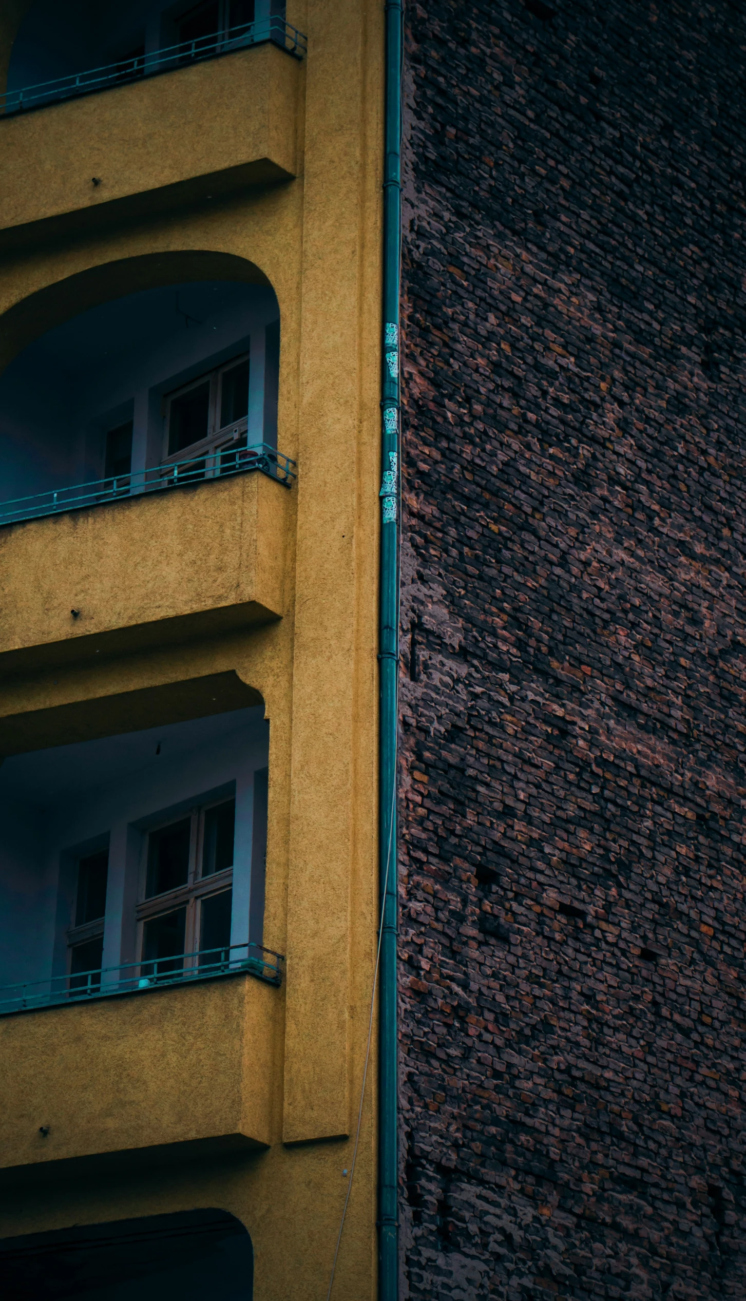 yellow building with windows near other building