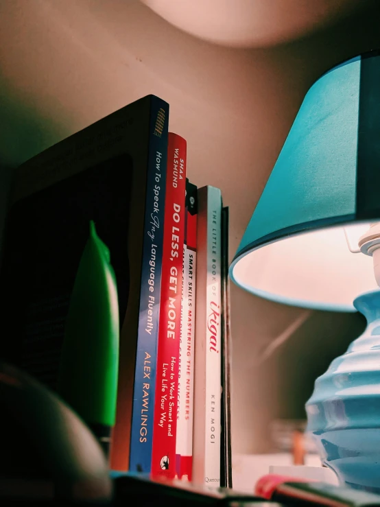 several books sit next to a lamp, which is also blue