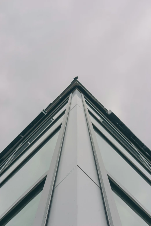 a tall building with several triangular windows against the sky