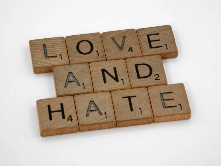 the scrabbled word love and hate is laid out on top of each other