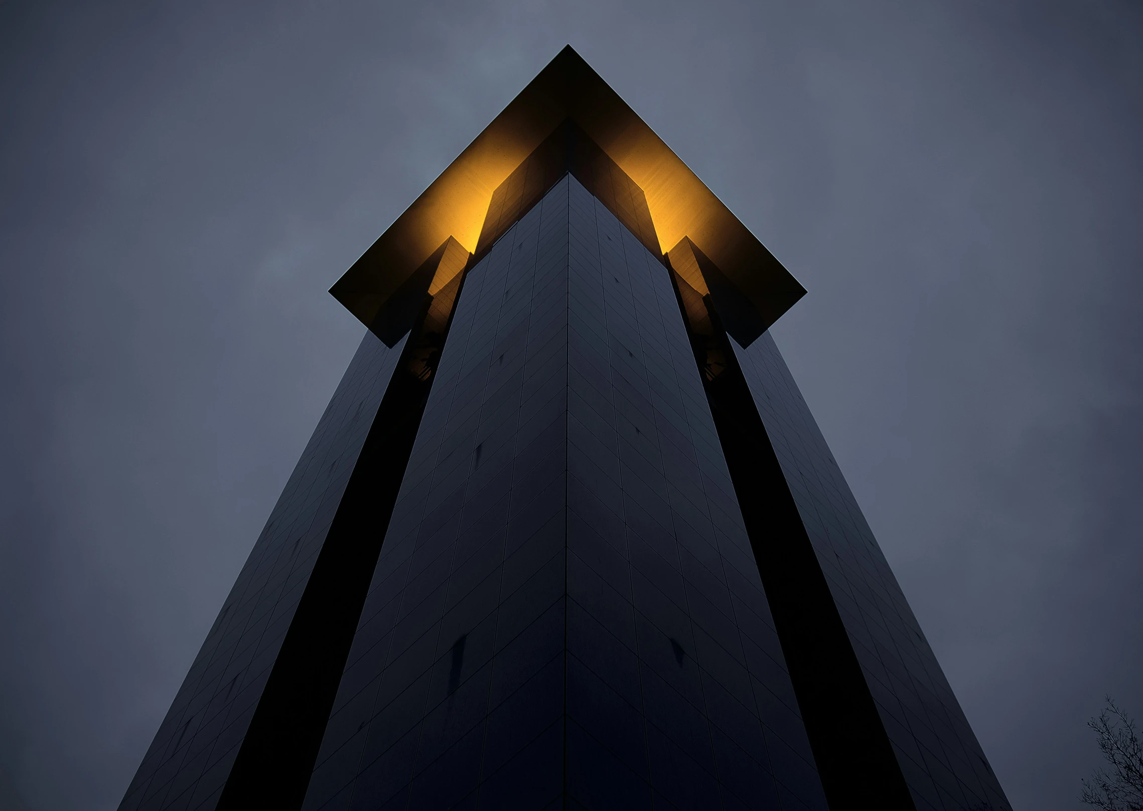 a tall building with two yellow lights in the side