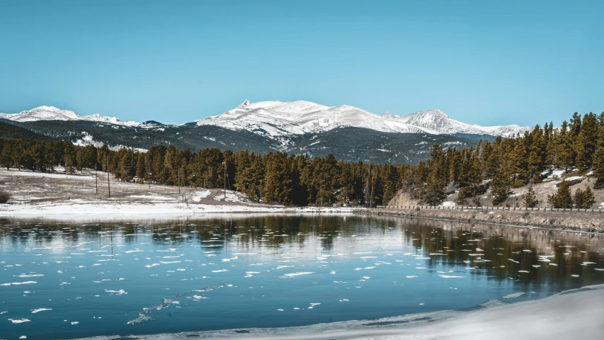 the sky is clear and blue over water and mountains