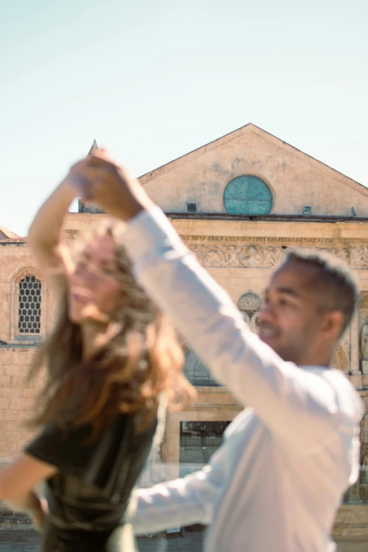 a man is dancing outside with his woman