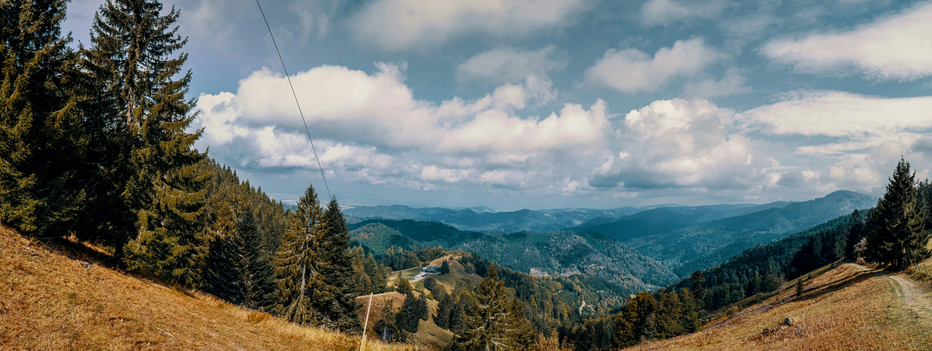 a view of some mountains and trees with clouds