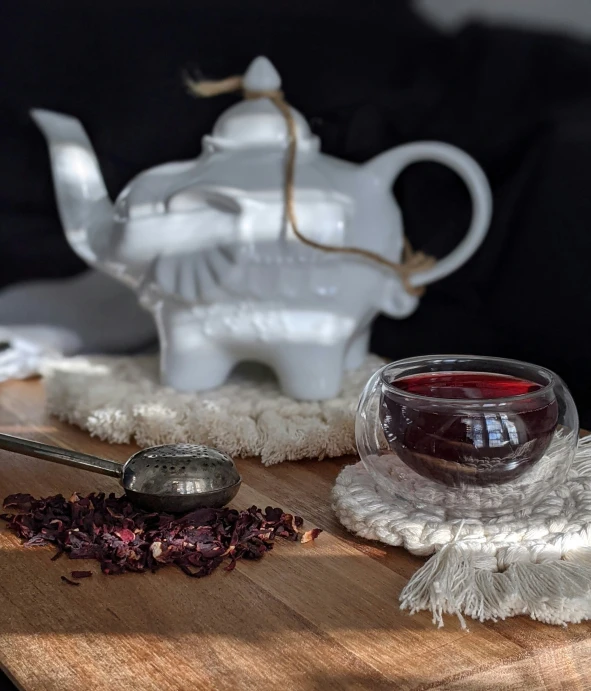 a tea cup and spoon sitting on a table