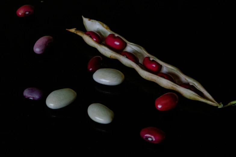 an arrangement of vegetables, one containing beans and cherries