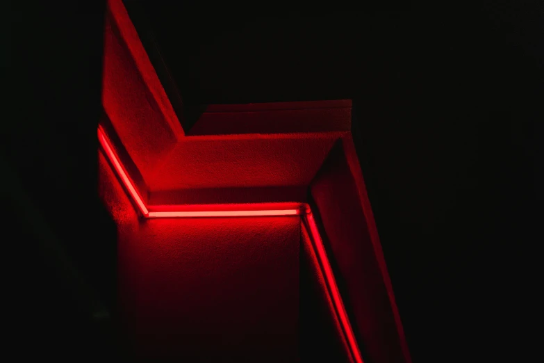 the corner of a dark room has a neon light