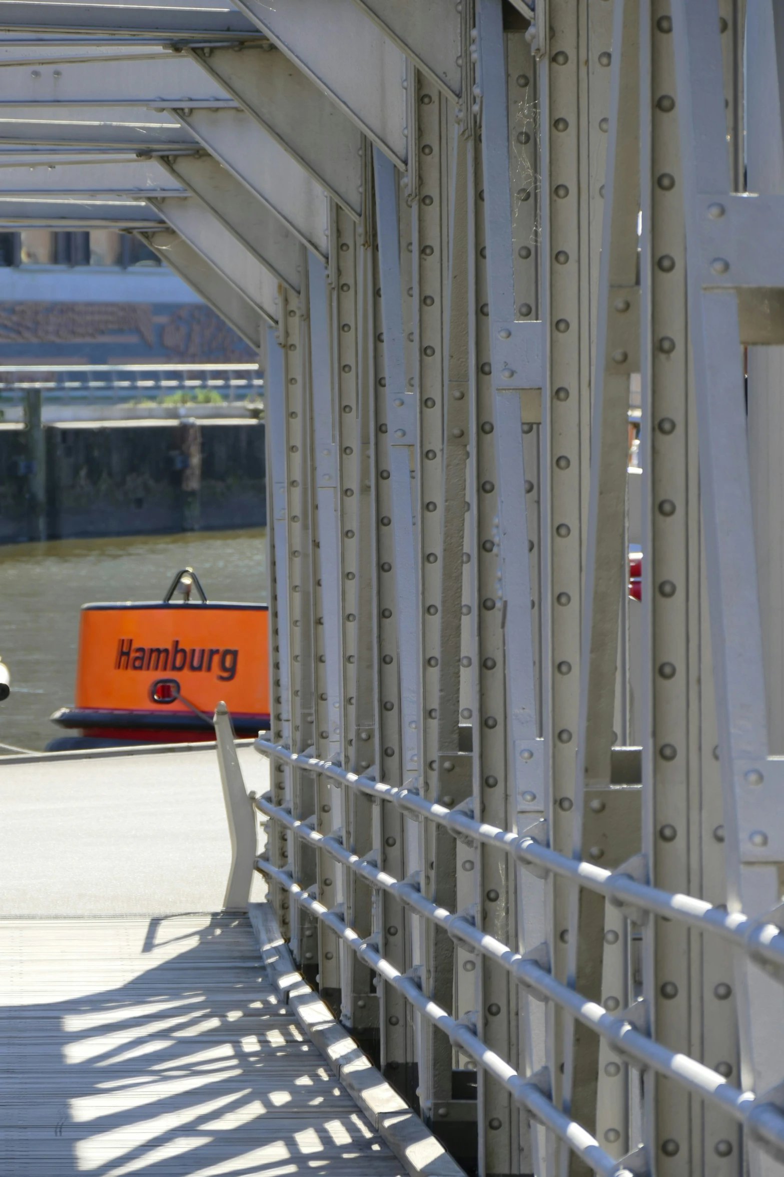 some white railing near some water and an orange sign