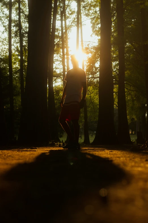 a man standing in the woods with his arms up