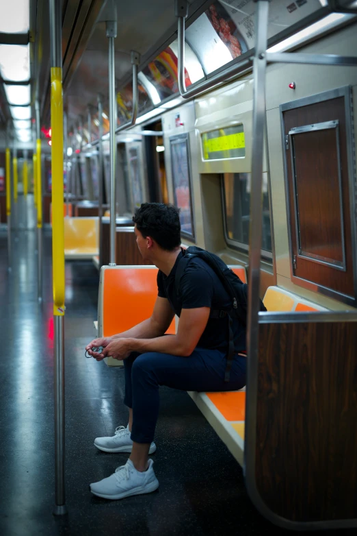 a man sits on a train seat holding a cellphone