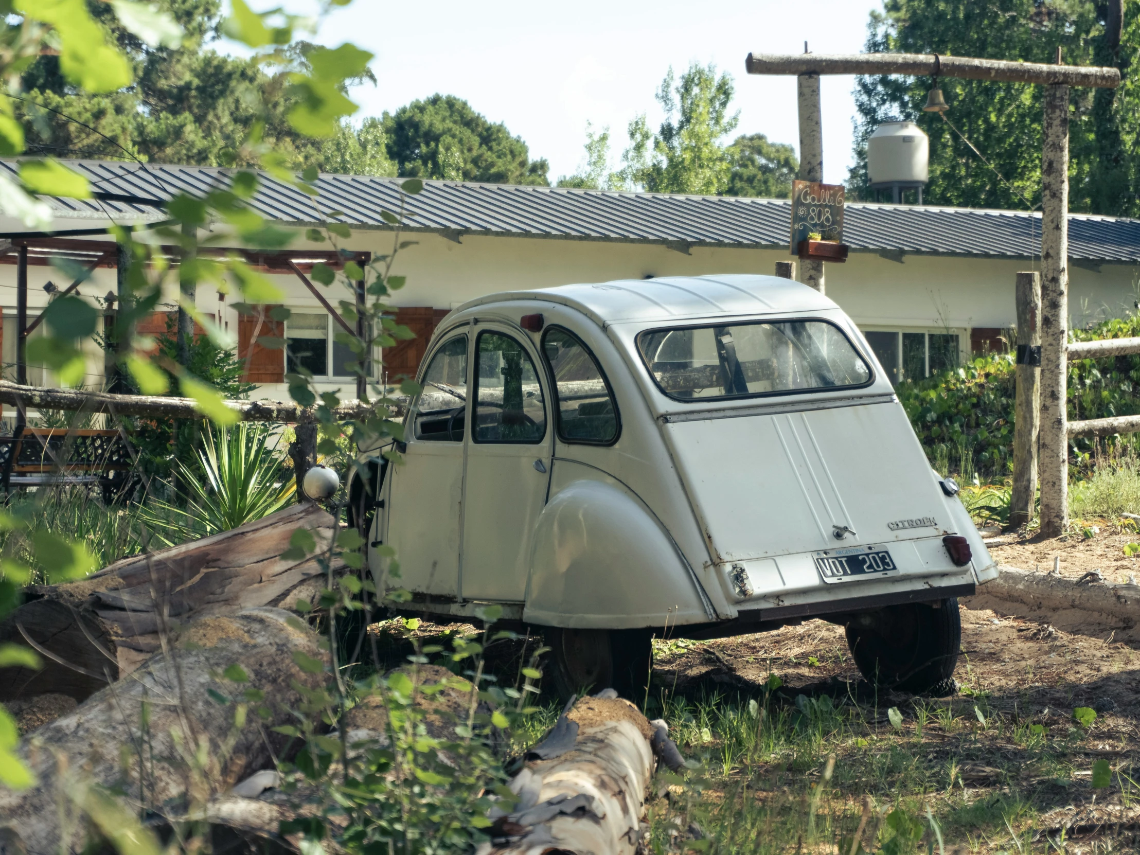 an old car is parked in the grass near a house