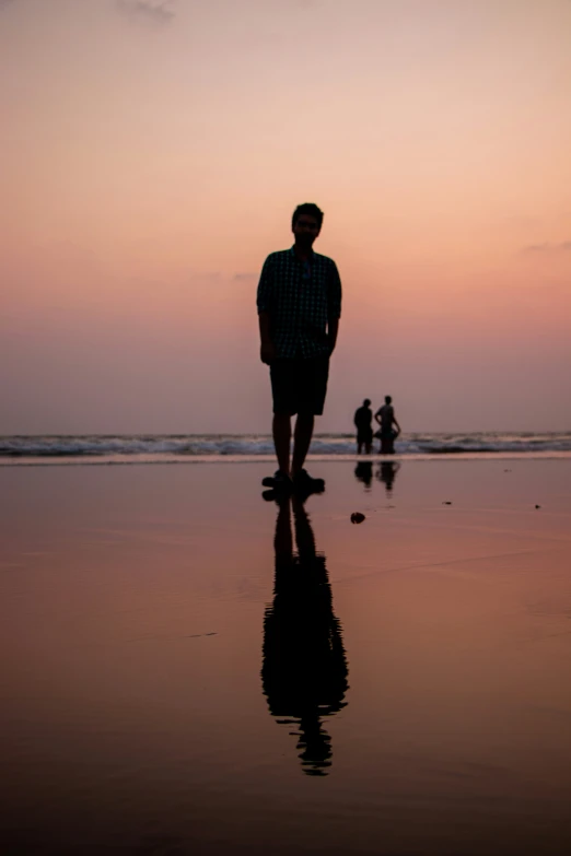 a man standing on the beach next to the ocean