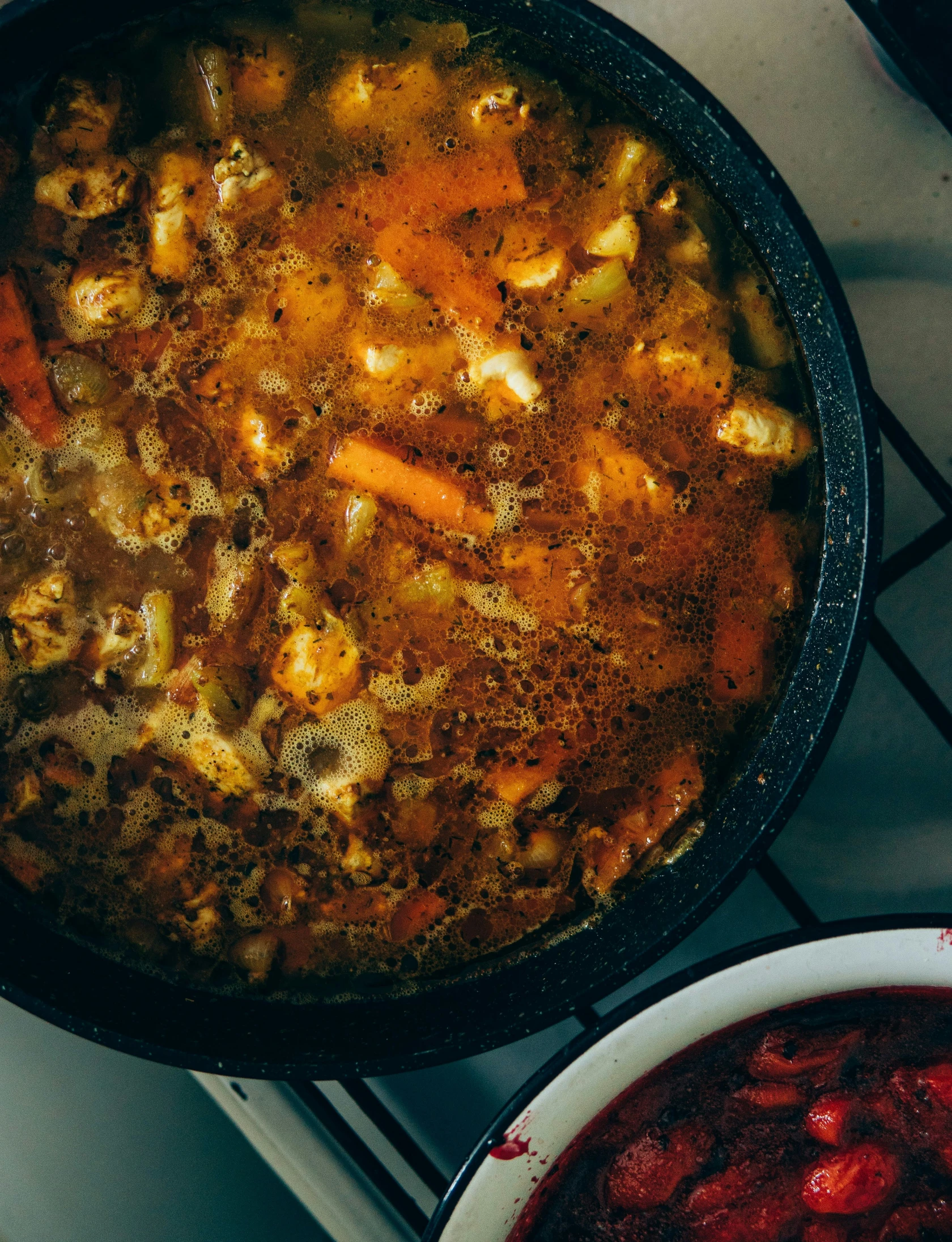 pot of food sitting on a stove with vegetables