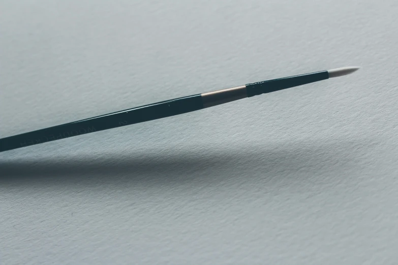 a black pencil on the back of a white background