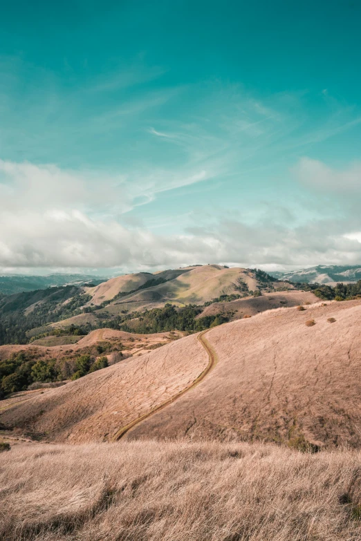 a view of the countryside and mountains from the top of a hill