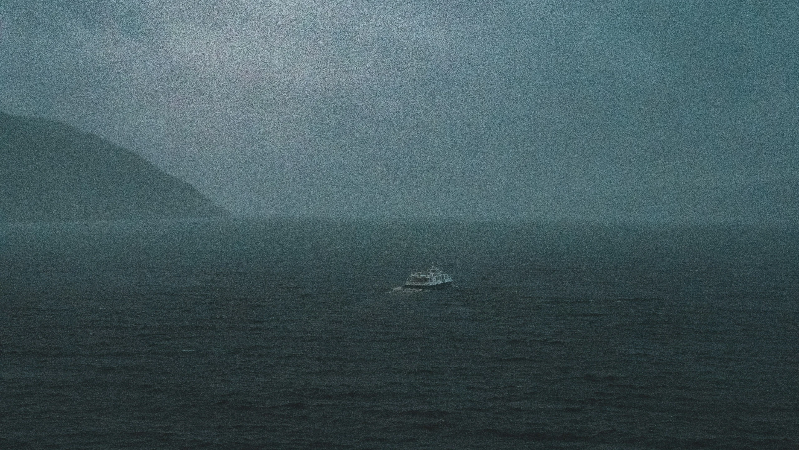 a sail boat sails in the dark ocean