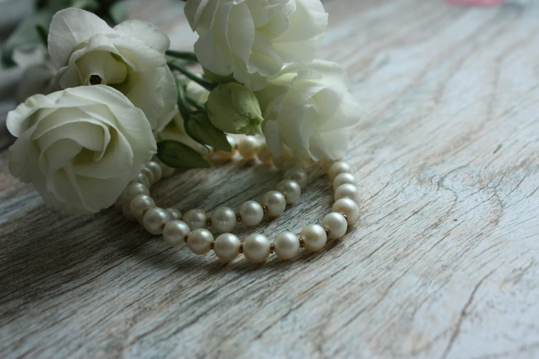 there is some white flowers and pearls on the table