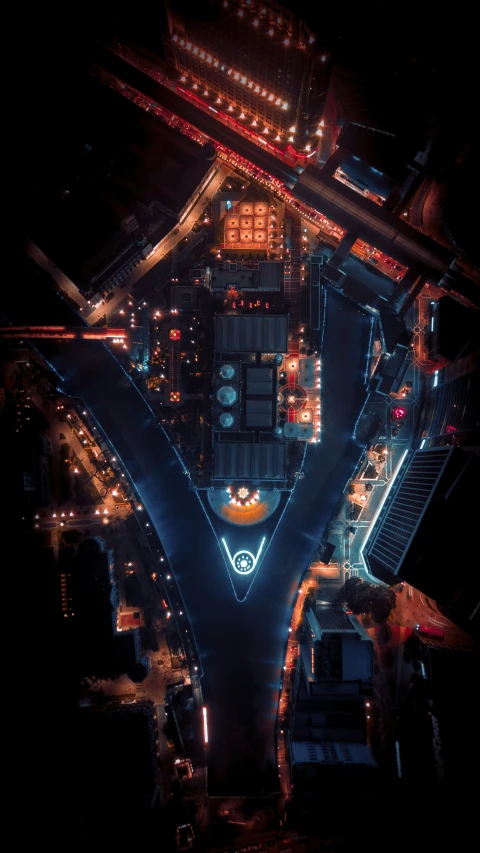 a large intersection at night with a clock on the side