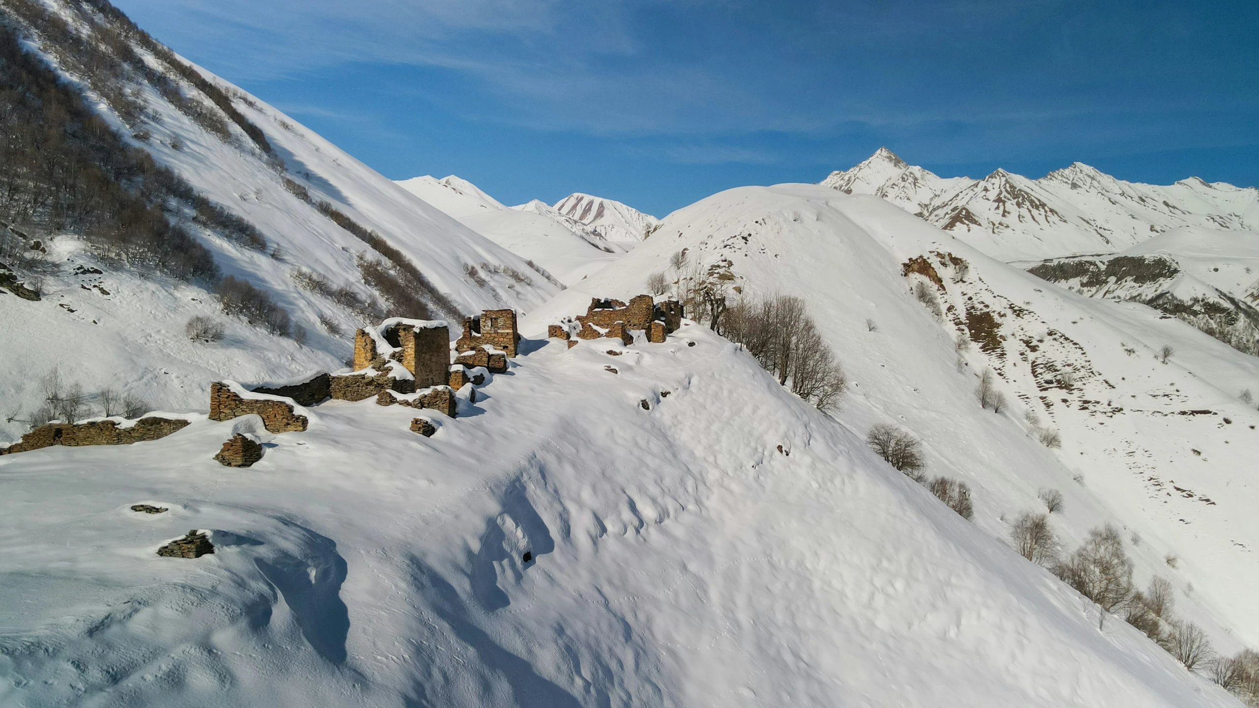 a mountain with a snowy slope, with many wooden cabins