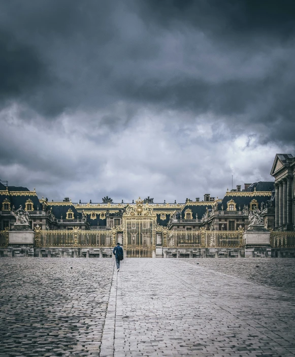 a man is walking down the street under a stormy sky