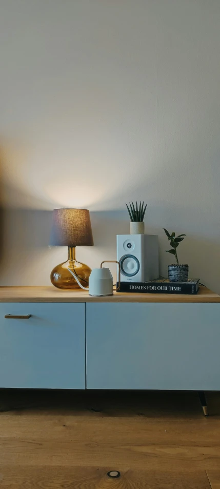 a modern white sideboard with a lamp and various items