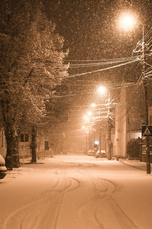 a street is covered with snow in the dark