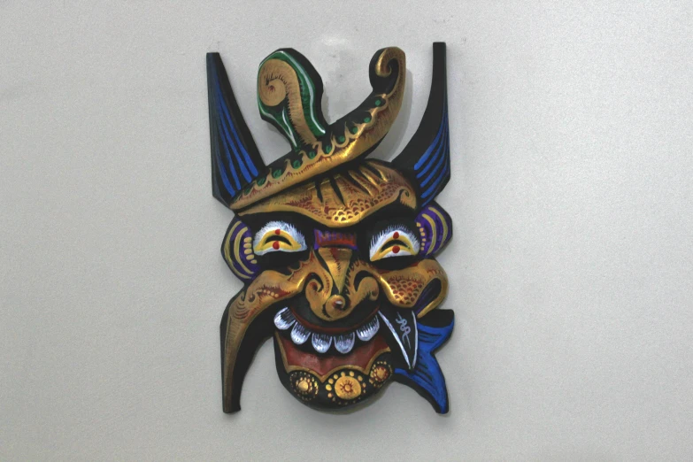 a wall mounted wooden mask with large horns