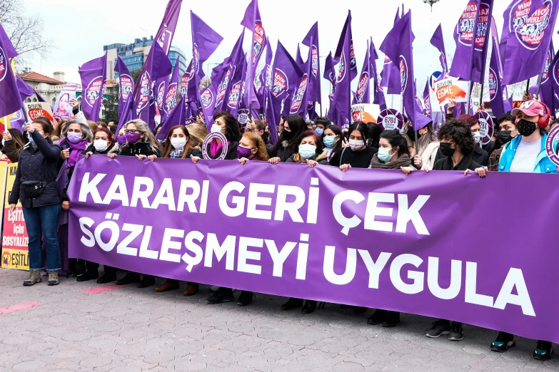 a group of people are holding a purple banner