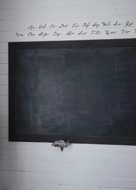 a blackboard mounted on the wall in an empty room