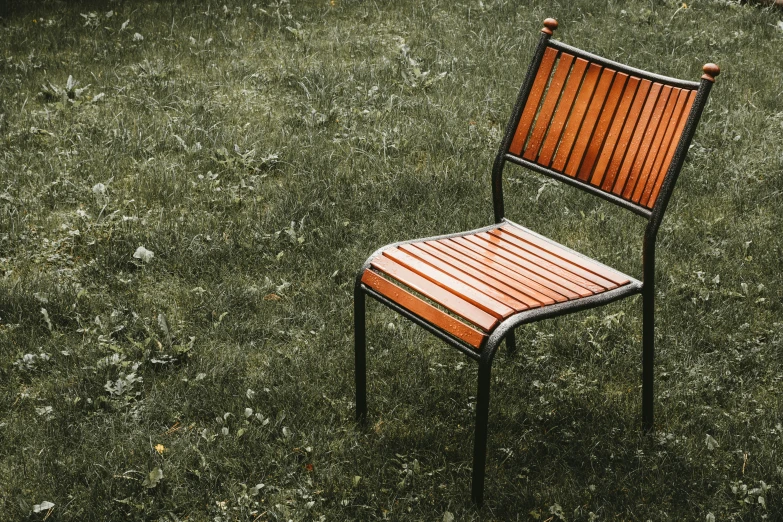 a brown and white chair in grass with one end off