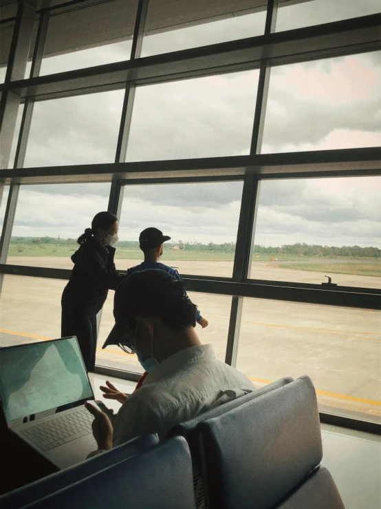 two people sitting on a bench at an airport