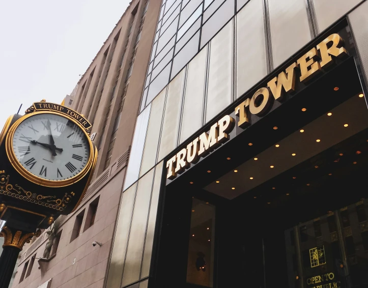 an old black and gold clock outside of a tower