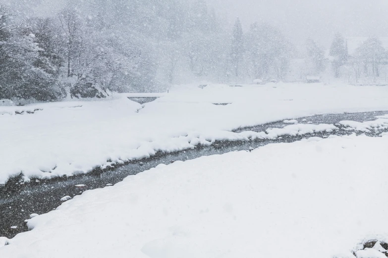 a couple of people walking down a snow covered road