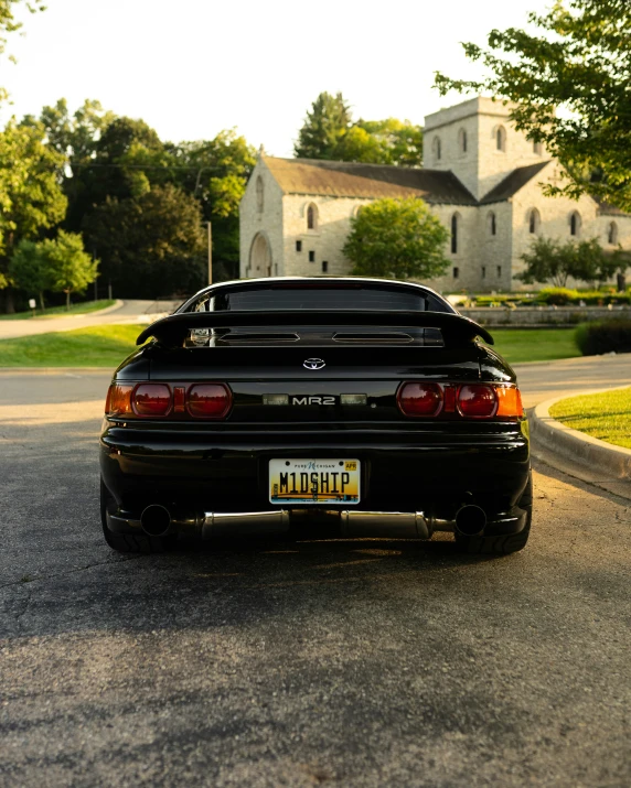 a car parked near a white house and a tree