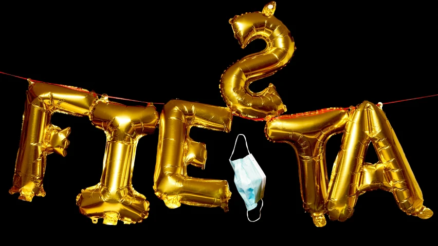 two golden balloons and a face mask are in front of an image that reads save the air