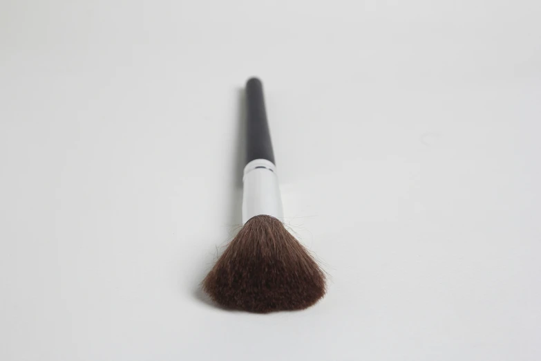 the makeup brush has black handle